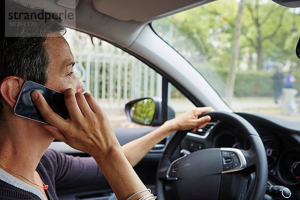 Frau fährt Auto  mit Smartphone