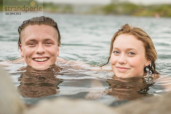 Porträt eines jungen Paares  das sich in der Secret Lagoon Thermalquelle (Gamla Laugin)  Fludir  Island  entspannen möchte.