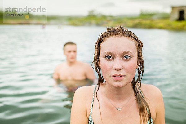Porträt einer jungen Frau vor ihrem Freund in der Secret Lagoon hot spring (Gamla Laugin)  Fludir  Island