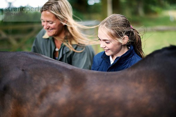 Mädchen und Mutter pflegendes Pferd