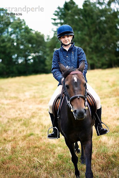 Portrait des Mädchens beim Reiten auf dem Feld