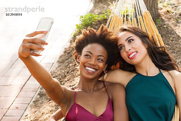 Junge Frauen nehmen Selfie in der Hängematte