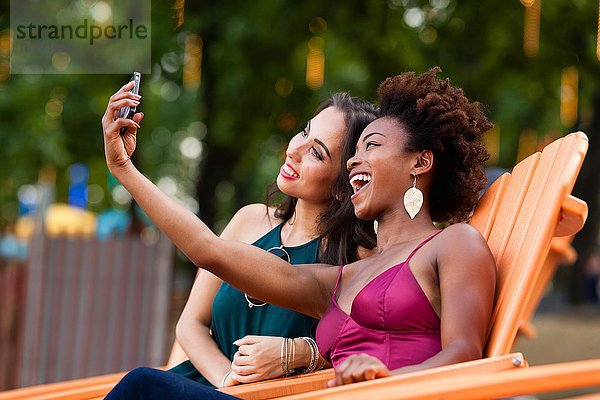 Junge Frauen  die Selfie im Liegestuhl nehmen