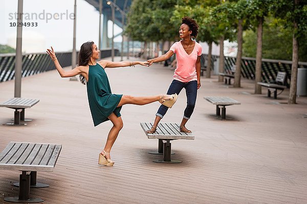 Junge Frauen tanzen und balancieren auf einem Bein
