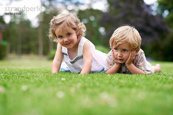 Oberflächenebene von Jungen und Mädchen auf Gras liegend