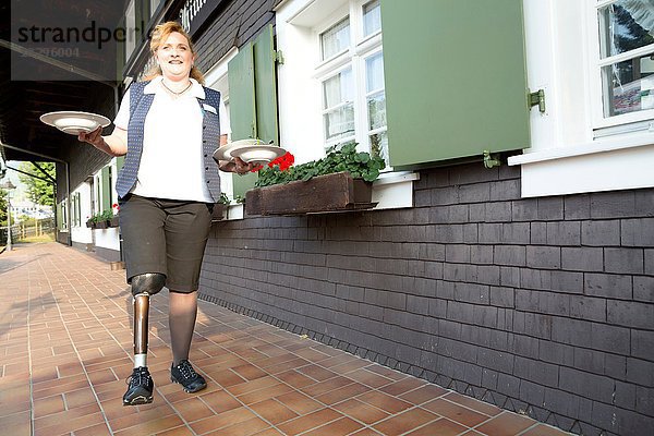 Mittlere erwachsene Frau mit Beinprothese  Trageplatten  im Freien