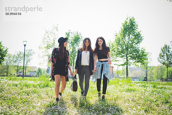 Drei junge Freundinnen beim Spaziergang im Park