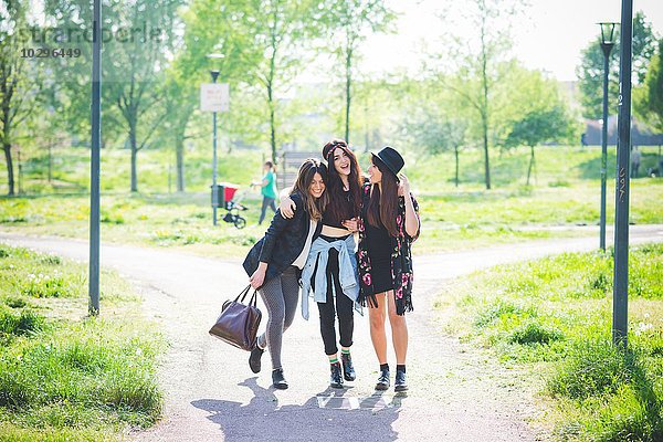 Drei junge Freundinnen beim gemeinsamen Spaziergang im Park