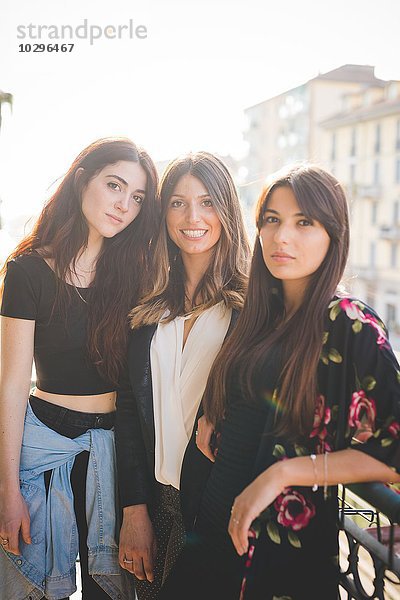 Porträt von drei jungen Freundinnen auf dem Stadtbalkon