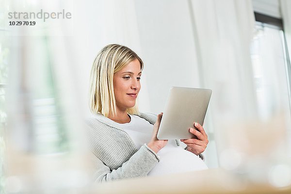 Vollzeitschwangerschaft junge Frau mit Touchscreen auf digitalem Tablett