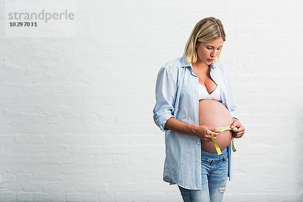 Vollzeitschwangerschaft junge Frau  die den Magen misst