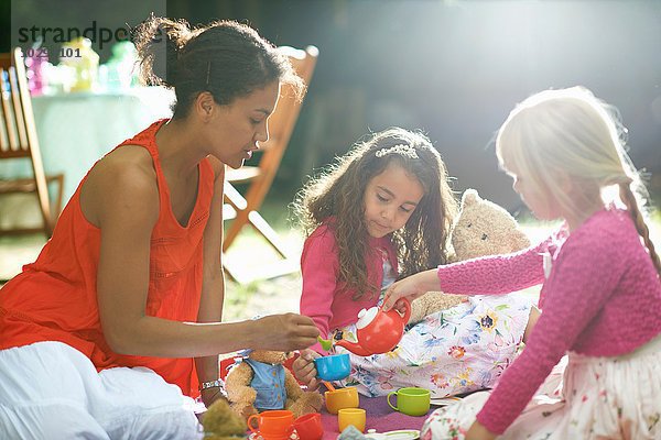 Mutter und zwei Mädchen beim Picknick auf der Gartengeburtstagsparty