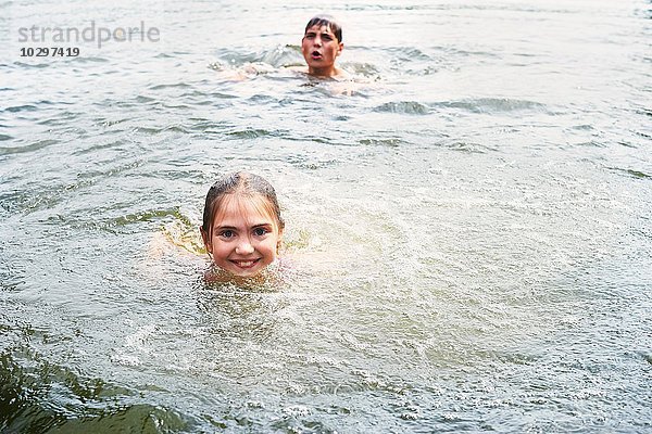 Teenager Junge und Schwester schwimmen im ländlichen See