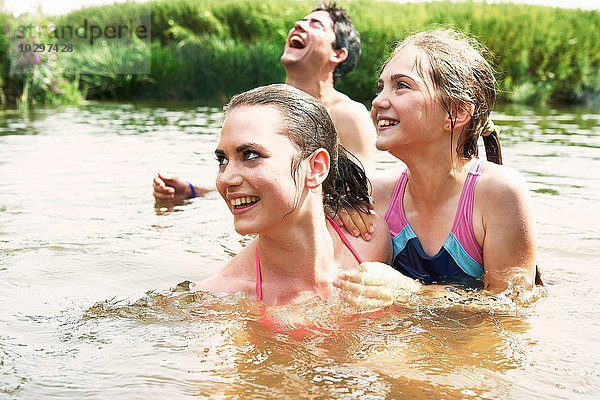 Zwei Schwestern und Freundinnen schwimmen im ländlichen See