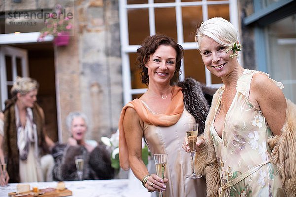 Elegante reife Frauen genießen Champagner im Stadtgarten