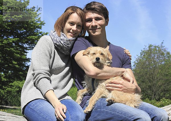 Glückliches junges Paar mit Terrier Dackel Mischling  Nordrhein-Westfalen  Deutschland  Europa