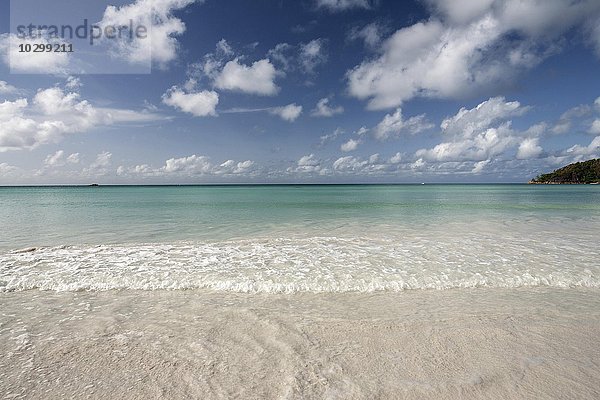 Weißer Sandstrand Anse Volbert  türkisblaues Wasser   blauer Himmel mit Wolken  indischer Ozean  Insel Praslin  Seychellen  Afrika