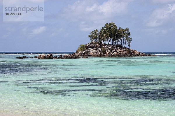 Kleine Granitinsel mit Baumbewuchs im türkisblauen Meer des Anse Royal  Insel Mahe  Seychellen  Afrika