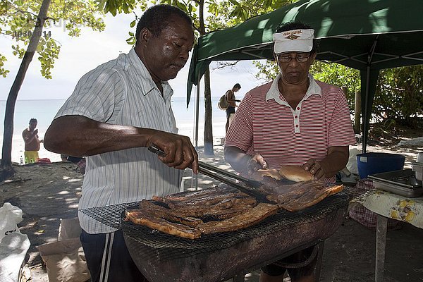 Straßengrill  einheimischer Mann grillt Fleisch am Straßenrand  nahe dem Strand von Beau Vallon  Insel Mahe  Seychellen  Afrika