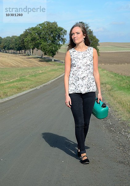 Junge Brünette mit Benzin kann auf Landstraße  Krageholm  Skåne län  Südschweden Fuß
