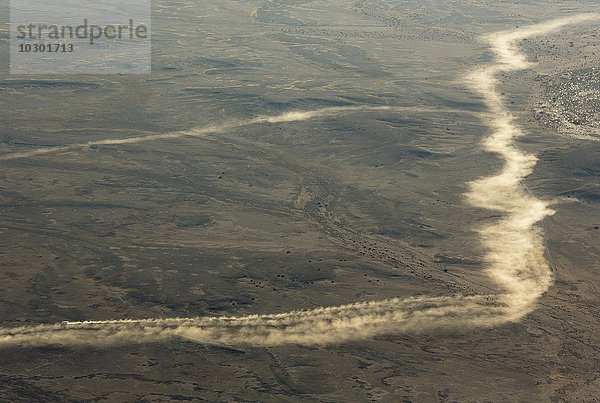 Luftbild aus einem Heißluftbalon  Staub von Fahrzeugen  die auf Schotterstraßen am Rande der Namib-Wüste fahren  Namib-Naukluft-Nationalpark  Namibia  Afrika
