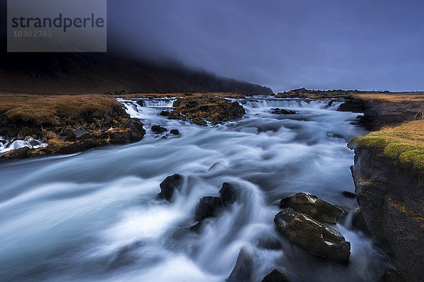Fluss Fossalar nahe Kirkjubaejarklaustur mit Gewitterwolken  Südisland  Island  Europa