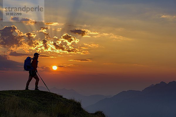 Bergsteiger im Gegenlicht bei Sonnenaufgang mit Bergen  Estergebirge  Ettal  Oberbayern  Bayern  Deutschland  Europa