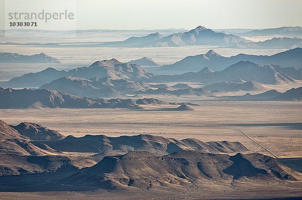 Isolierte Bergrücken am Rande der Namib-Wüste  Küstennebel hinten  Luftbild  NamibRand-Naturreservat  Namibia  Afrika