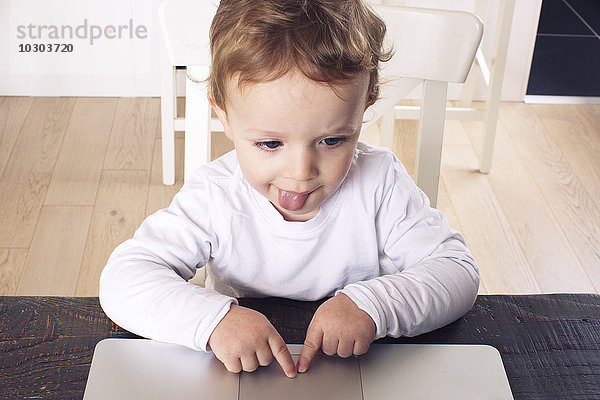Kleiner Junge mit Touchpad auf Laptop-Computer