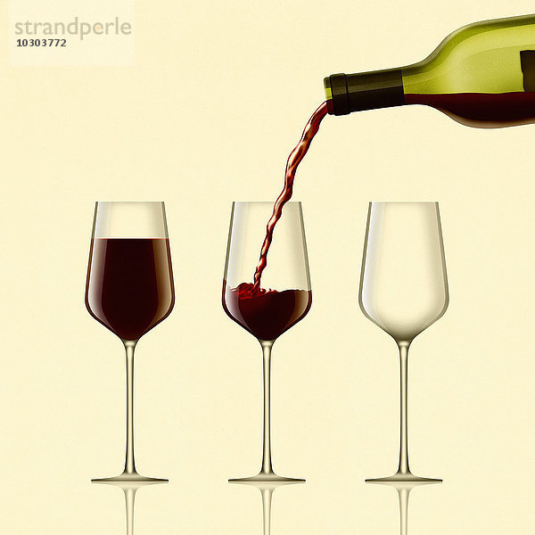 Rotwein wird in drei Gläser gegossen