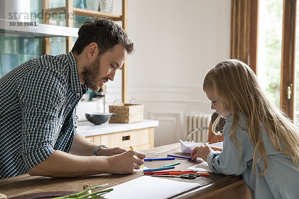 Vater und Tochter zeichnen zu Hause