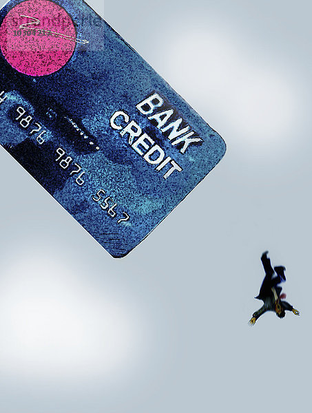 Geschäftsmann fällt von großer Kreditkarte