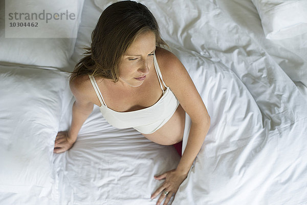 Schwangere Frau beim Aufwachen im Bett