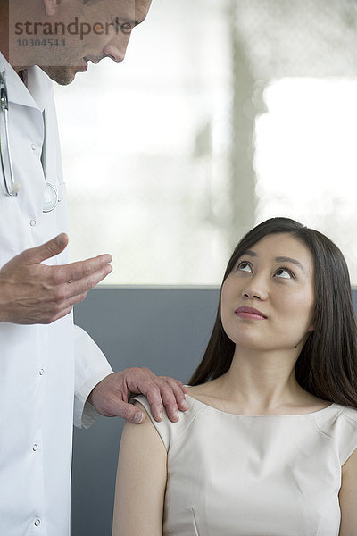 Arzt spricht mit Patient im Wartezimmer
