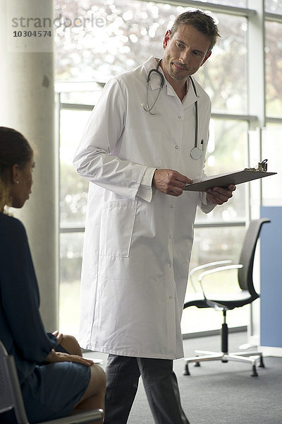 Arzt im Gespräch mit dem Patienten im Wartezimmer