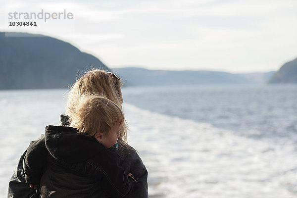 Mutter und Sohn mit Blick auf den ruhigen See