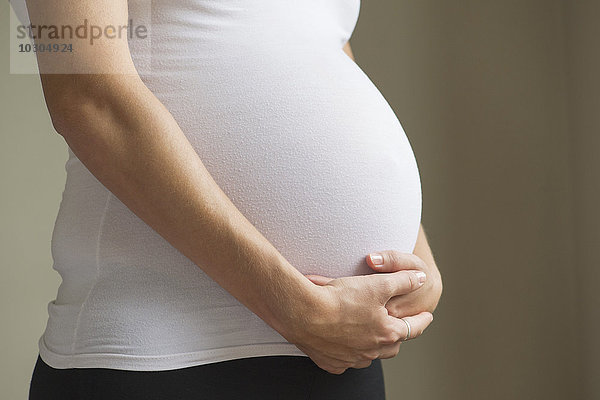 Schwangere Frau beim Wiegen des Bauches