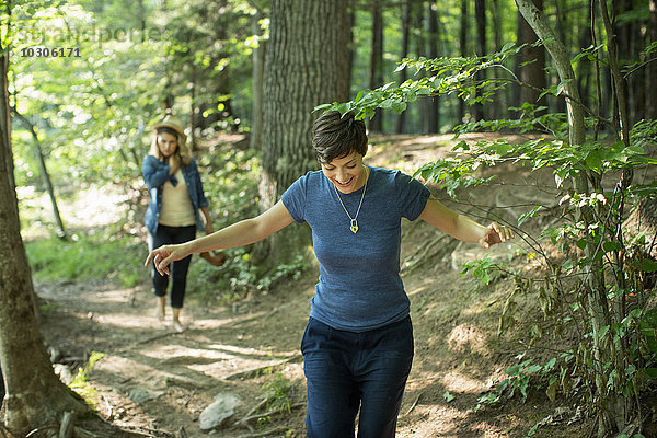 Zwei Frauen gehen einen Waldweg entlang.