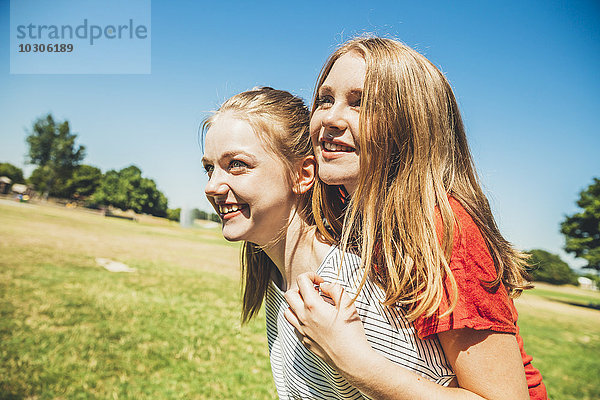 Teenager Mädchen mit Freund Huckepack im Park