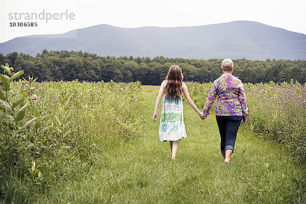 Eine reife Frau und ein junges Mädchen auf einer Wildblumenwiese.