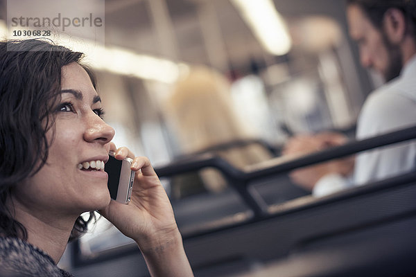 Eine Frau in einem Stadtbus  die mit ihrem Handy telefoniert