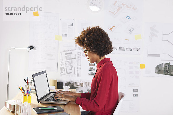 Junge Architektin mit Laptop im Büro