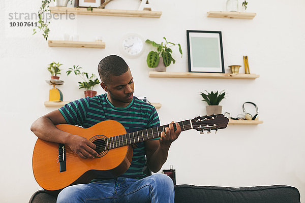 Mann  der zu Hause Gitarre spielt