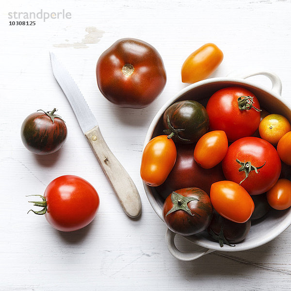 Verschiedene Tomaten  Zebrino  Ebeno  Devotion und gelbe Kirschtomaten in Schale  Küchenmesser