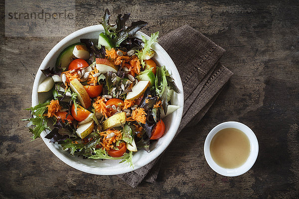 Frischer gemischter Salat mit Kohlrabi  Tomate und Gurke auf Holz
