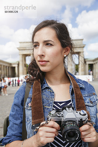 Deutschland  Berlin  Portrait einer Touristin mit Kamera