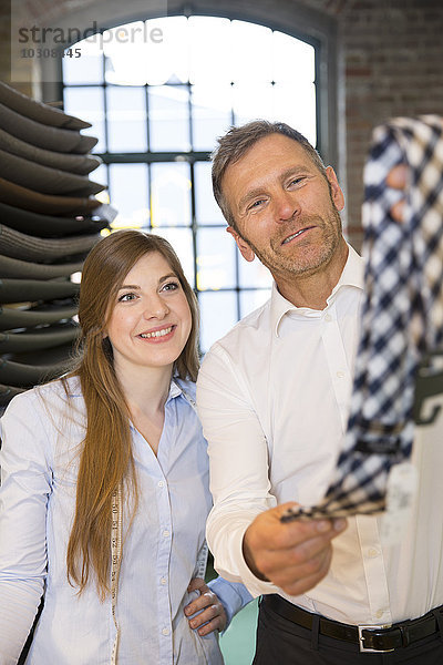 Junge Frau hilft dem Kunden bei der Wahl der Krawatte