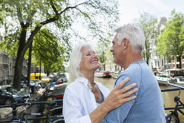 Niederlande  Amsterdam  glückliches Seniorenpaar am Stadtkanal