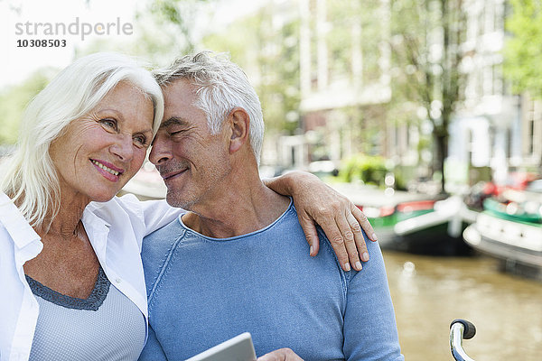 Niederlande  Amsterdam  lächelndes Seniorenpaar am Stadtkanal