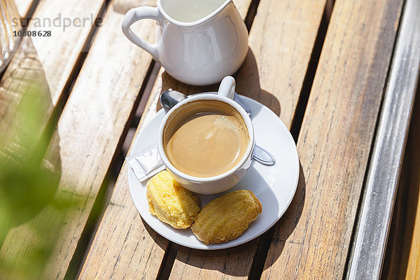 Tasse Kaffee mit Keksen auf dem Tisch im Freien